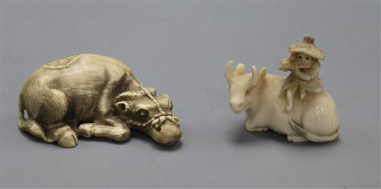 Two early 20th century Japanese ivory netsukes of an ox, one surmounted by a man (547, 593)